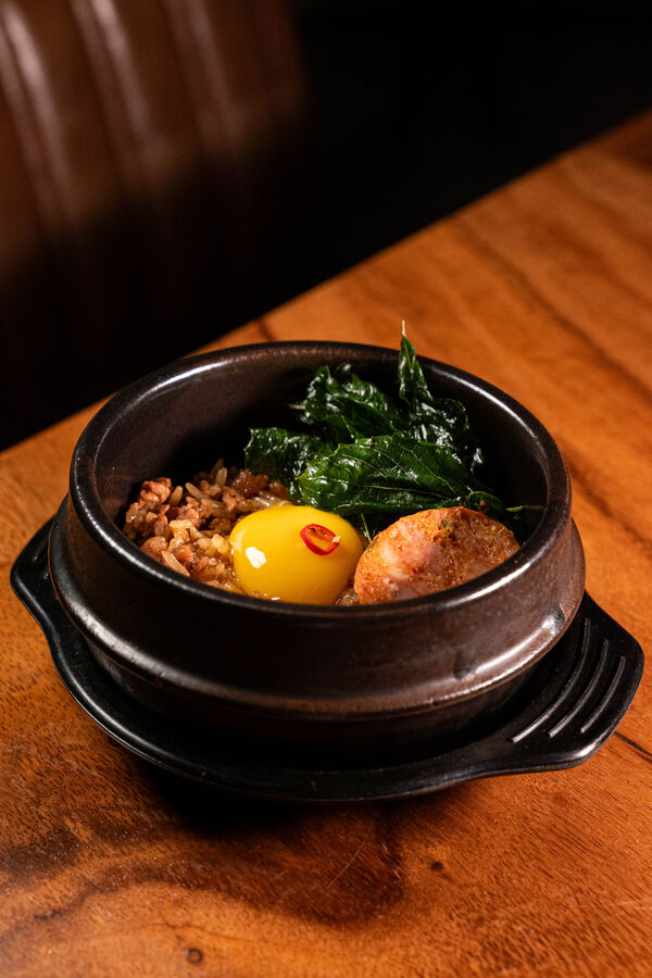 Krapao bibimbap — holy basil pork, rice and egg yolk in a clay pot
